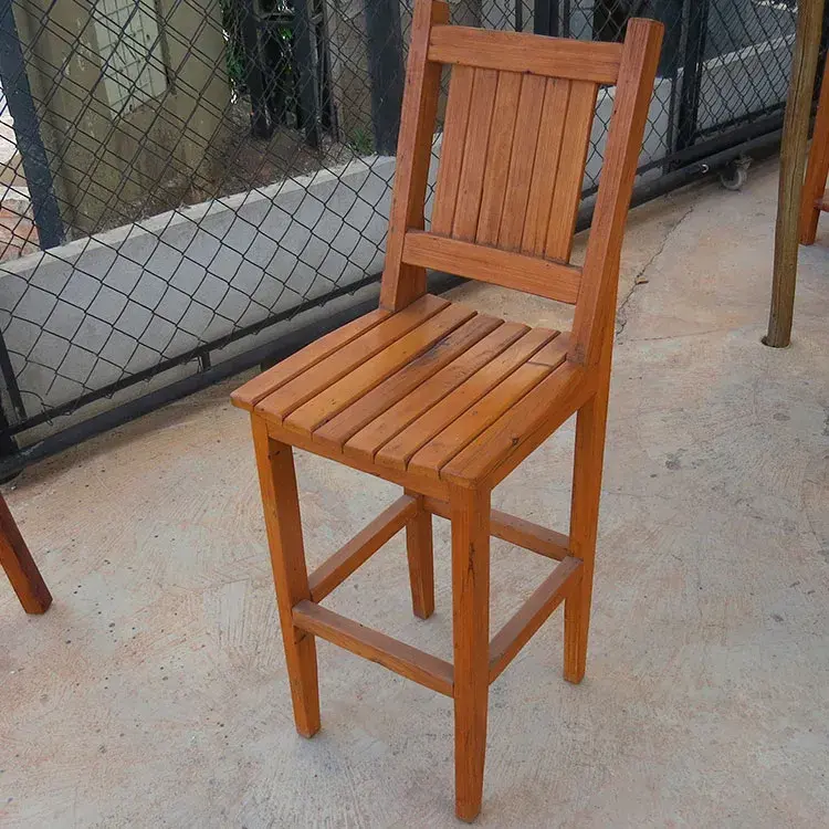 Banqueta alta de peroba rosa com encosto de filetes colados, altura do assento de 0,63m e encosto de 0,83m.