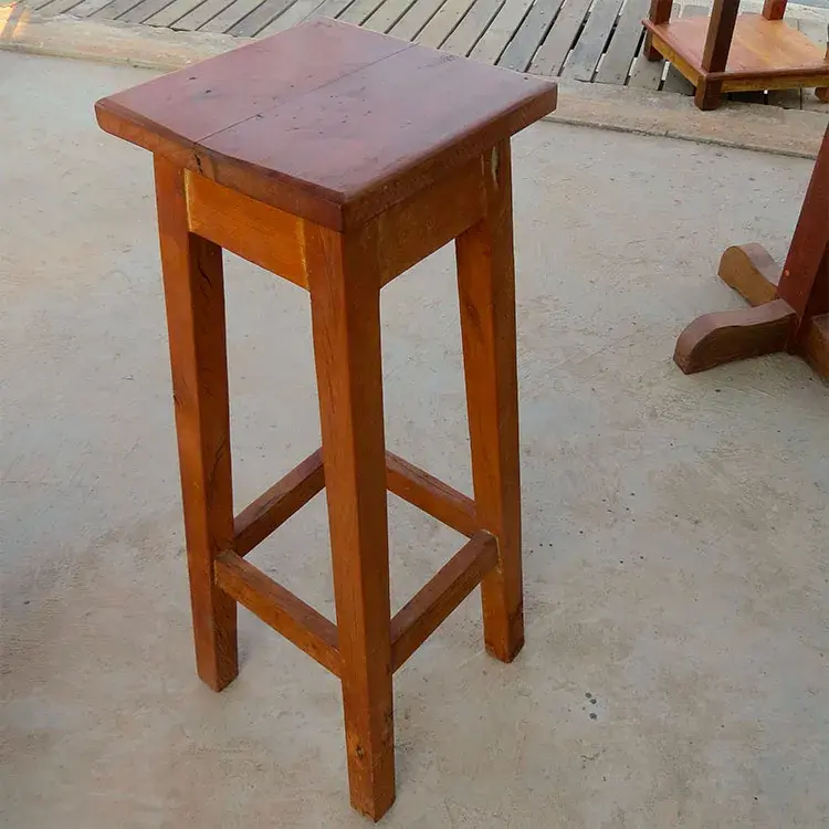 Banqueta alta de peroba rosa sem encosto, com altura de 0,67m, design compacto e rústico.