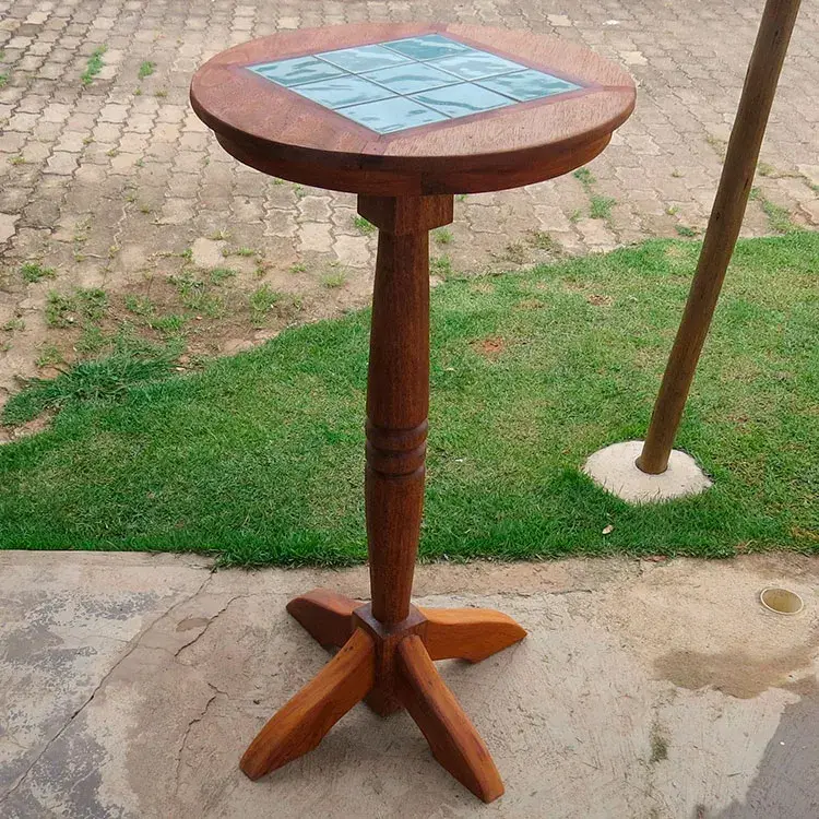 Bistrô em madeira mista com tampo decorado com pastilhas, pé trabalhado, altura de 1,05m e diâmetro de 0,50m.