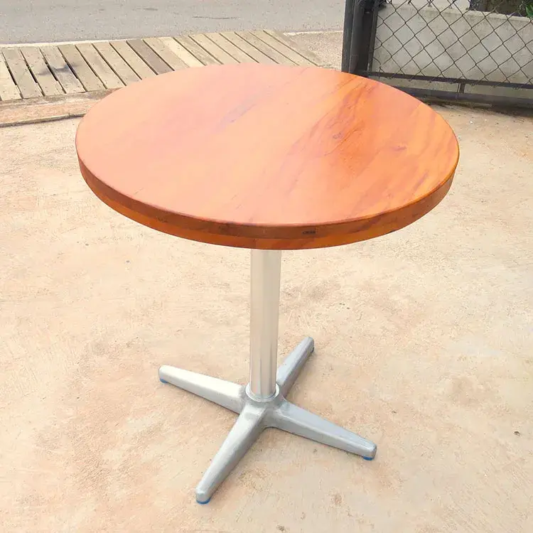 Mesa bar redonda com tampo em peroba natural, tons de caramelo, diâmetro de 62cm e base em alumínio.