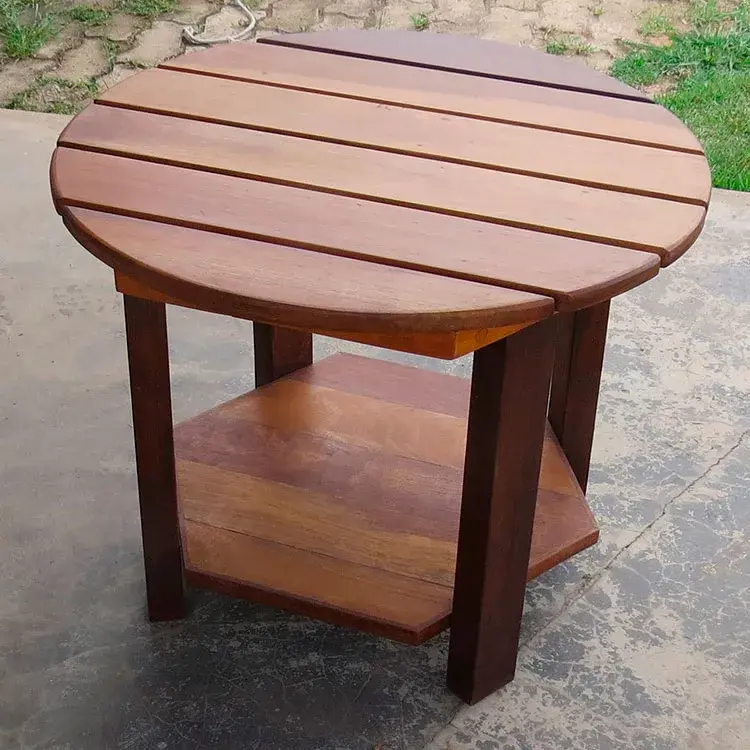 Mesa de centro redonda em ipê natural, tons castanho escuros, com diâmetro de 50cm e base hexagonal. Altura de 40cm.
